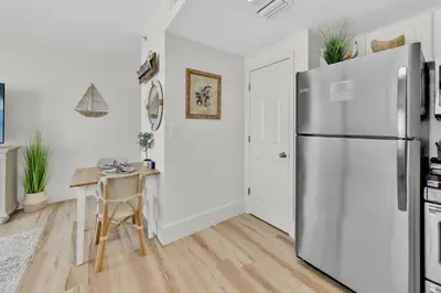 a kitchen with a stainless steel refrigerator and a table at Beachfront Studio #509 at Majestic in Panama City Beach