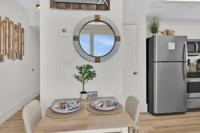 a dining room with a table and a refrigerator at Beachfront Studio #509 at Majestic in Panama City Beach