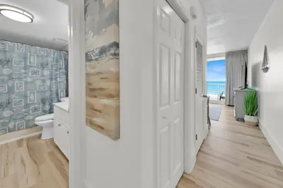 a hallway with a white bathroom with a view of the ocean at Beachfront Studio #509 at Majestic in Panama City Beach