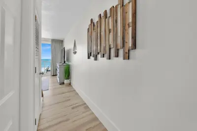 a hallway of a house with white walls and wood floors at Beachfront Studio #509 at Majestic in Panama City Beach