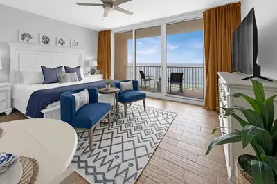 a hotel room with a bed and a balcony at Beachfront Studio #809 at Majestic in Panama City Beach