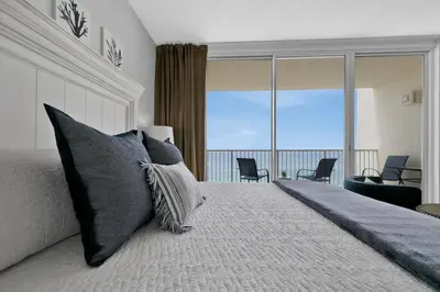 a bedroom with a bed with a view of a balcony at Beachfront Studio #809 at Majestic in Panama City Beach