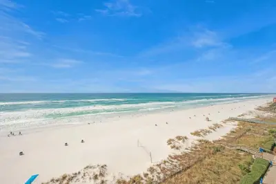 a group of people on a beach near the ocean at Beachfront Studio #809 at Majestic in Panama City Beach