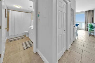 a bathroom with a toilet and a door with a balcony at Beachfront Studio #809 at Majestic in Panama City Beach