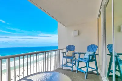 a balcony with chairs and a table and the ocean at Beachfront Studio #909 at Majestic in Panama City Beach