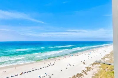 a group of people on a beach with the ocean at Beachfront Studio #909 at Majestic in Panama City Beach