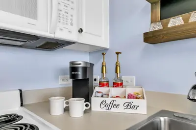 a kitchen counter with a coffee box with bottles of wine at Beachfront Studio #909 at Majestic in Panama City Beach
