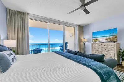 a bedroom with a large bed with a view of the ocean at Beachfront Studio #909 at Majestic in Panama City Beach