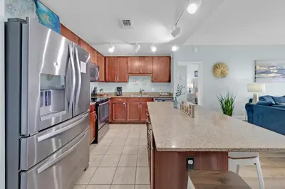 a large kitchen with a stainless steel refrigerator at Gulfview Condo #1809 at Laketown Wharf in Panama City Beach