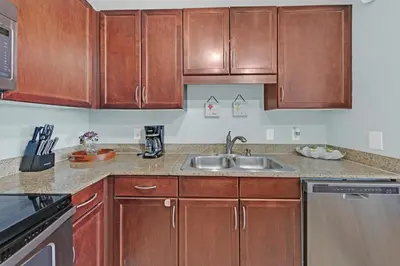 a kitchen with wooden cabinets and a sink at Gulfview Condo #1809 at Laketown Wharf in Panama City Beach