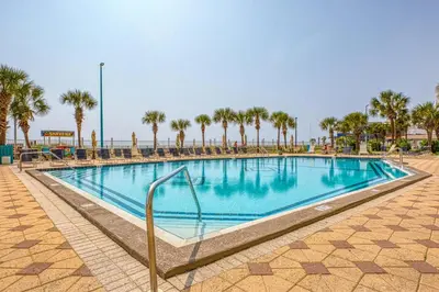 a swimming pool at a resort with palm trees at Oceanfront Condo #1320 at Summit in Panama City Beach