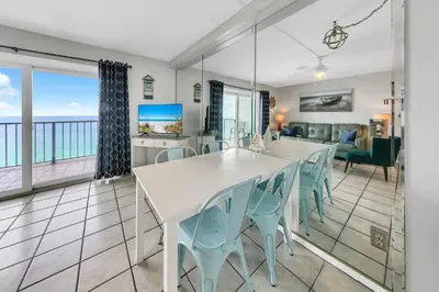 a dining room with a white table and chairs at Oceanfront Condo #1320 at Summit in Panama City Beach