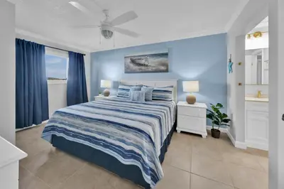a bedroom with a bed with a blue wall at Oceanfront Condo #507 at Summit Beach Resort in Panama City Beach
