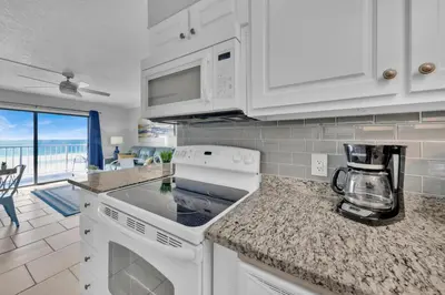 a kitchen with white cabinets and a counter top at Oceanfront Condo #507 at Summit Beach Resort in Panama City Beach