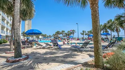 a group of people sitting in chairs by a swimming pool at Oceanfront Condo #507 at Summit Beach Resort in Panama City Beach