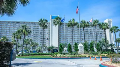 a large building with palm trees in front of it at Oceanfront Condo #507 at Summit Beach Resort in Panama City Beach