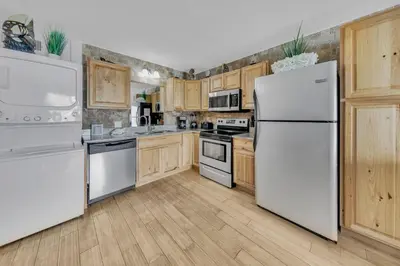 a kitchen with white appliances and wooden cabinets at Oceanfront Condo #629 at Summit Beach Resort in Panama City Beach
