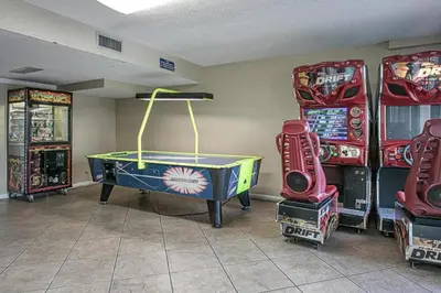 a room with arcade games and a ping pong table at Oceanfront Condo #629 at Summit Beach Resort in Panama City Beach