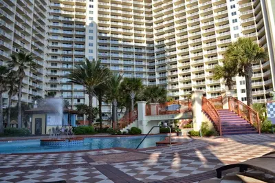 a resort with a pool and palm trees and buildings at Shores of Panama # 1902 condo in Panama City Beach