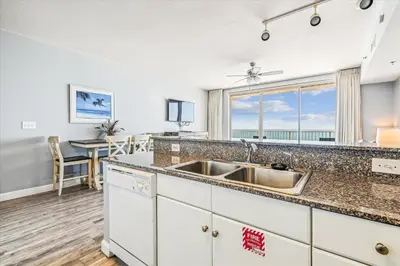 a kitchen with a sink and a dining room with a table at Shores of Panama # 1902 condo in Panama City Beach