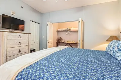 a bedroom with a bed and a dresser and a tv at Shores of Panama # 1902 condo in Panama City Beach