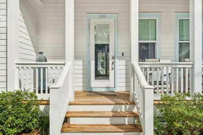 a white house with a blue door and stairs at 30A Beach House - Beach Please by Panhandle Getaways in Santa Rosa Beach