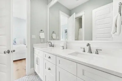 a white bathroom with two sinks and a mirror at 30A Beach House - Beach Please by Panhandle Getaways in Santa Rosa Beach