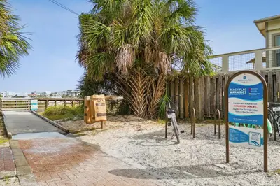 a sign in the sand next to a palm tree at 30A Beach House - Beach Please by Panhandle Getaways in Santa Rosa Beach