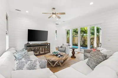 a living room with white furniture and a flat screen tv at 30A Beach House - Beach Please by Panhandle Getaways in Santa Rosa Beach
