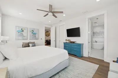 a white bedroom with a bed and a blue dresser at 30A Beach House - Cozinest at Treetops by Panhandle Getaways in Rosemary Beach