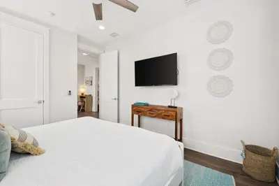 a bedroom with a bed and a tv on the wall at 30A Beach House - Cozinest at Treetops by Panhandle Getaways in Rosemary Beach