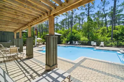 an outdoor swimming pool with a wooden pergola at 30A Beach House - Cozinest at Treetops by Panhandle Getaways in Rosemary Beach