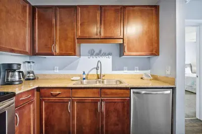 a kitchen with wooden cabinets and a sink at Laketown Wharf #1807 by Nautical Properties in Panama City Beach