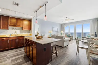a kitchen and living room with a view of the ocean at Laketown Wharf #1807 by Nautical Properties in Panama City Beach
