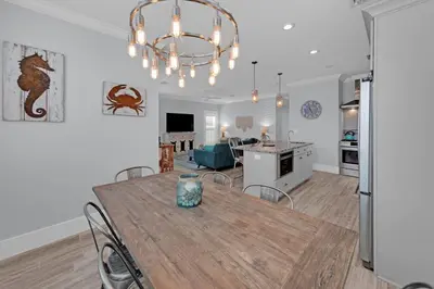 a dining room and kitchen with a table and chairs at Sea Suite - Large hot tub with an easy walk to the beach in Santa Rosa Beach