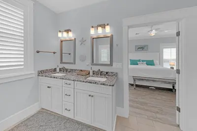 a bathroom with two sinks and a bedroom with a bed at Sea Suite - Large hot tub with an easy walk to the beach in Santa Rosa Beach