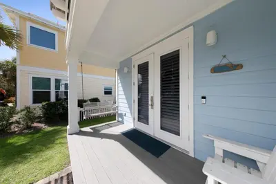 a porch of a house with a bench on it at Sea Suite - Large hot tub with an easy walk to the beach in Santa Rosa Beach