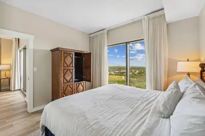 a bedroom with a large bed and a large window at Origin at Seahaven #1703 by Nautical Properties in Panama City Beach
