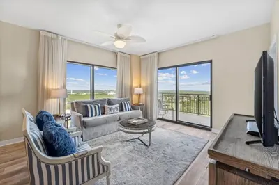 a living room with a couch and a tv at Origin at Seahaven #1703 by Nautical Properties in Panama City Beach