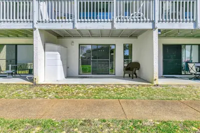 a white house with a chair on a patio at Endless Summer E2 in Panama City Beach
