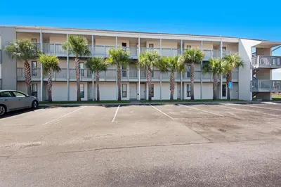 a parking lot in front of a building with palm trees at Endless Summer E2 in Panama City Beach