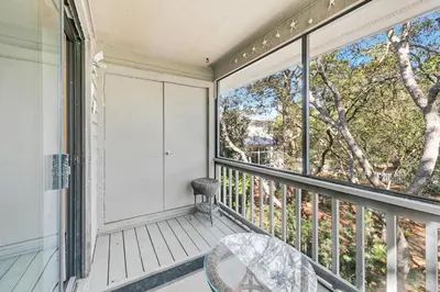 a balcony with a chair and a large window at Cassine Gardens 212 in Santa Rosa Beach