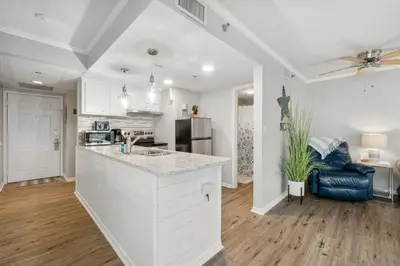 a white kitchen with a sink and a counter at Sunbird Resort! Incredible Beachfront Corner Unit! Free Beach Chairs! by Dolce Vita Getaways PCB in Panama City Beach