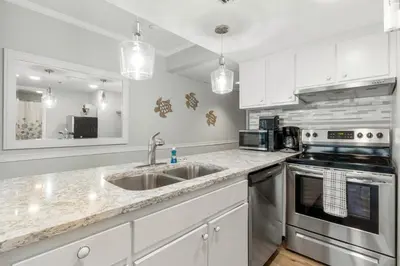 a kitchen with a sink and a stove at Sunbird Resort! Incredible Beachfront Corner Unit! Free Beach Chairs! by Dolce Vita Getaways PCB in Panama City Beach