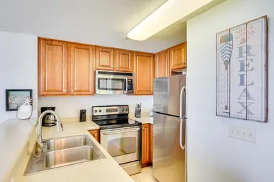 a kitchen with wooden cabinets and stainless steel appliances at Panama City Beach Paradise with Pool and Hot Tub! in Panama City Beach