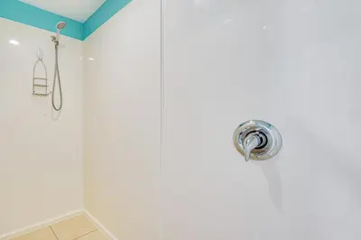 a bathroom with a shower with white walls at Panama City Beach Paradise with Pool and Hot Tub! in Panama City Beach