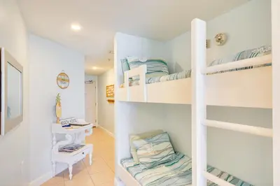 a room with bunk beds and a desk at Panama City Beach Paradise with Pool and Hot Tub! in Panama City Beach