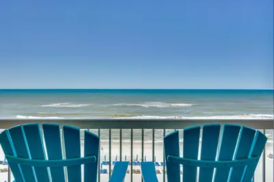 two blue chairs on a beach with the ocean at Panama City Beach Paradise with Pool and Hot Tub! in Panama City Beach