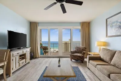 a living room with a couch and a tv and a table at Laketown Wharf #1106 by Nautical Properties in Panama City Beach