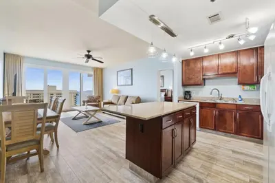 a kitchen and living room with a table and a dining room at Laketown Wharf #1106 by Nautical Properties in Panama City Beach